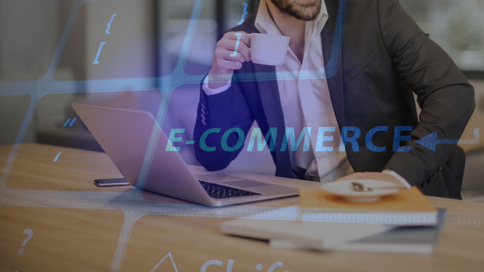 Muž v obleku s kávou pri notebooku a digitálny nápis E-COMMERCE – čo robí E-commerce Manager